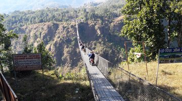 Motorcycle in the middle of a valley footbridge